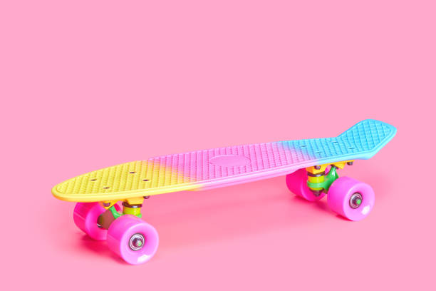 istock rainbow plastic Penny board skateboard isolated on pink background 1327044337