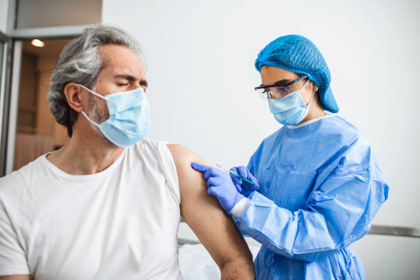 istock General practitioner vaccinating old patient in clinic with copy space. Doctor giving injection to senior man at hospital. Nurse holding syringe before giving Covid-19 or coronavirus vaccine. 1327044914