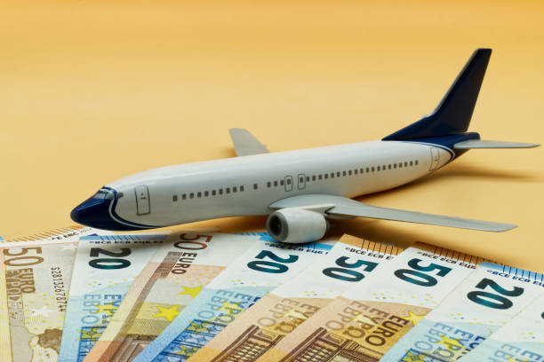 Commercial airplane toy and a pile of Euro banknotes. Flights cost concept stock photo