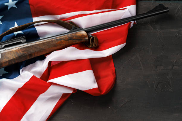istock Automatic rifle on USA flag on wooden background 1327048842