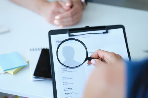 istock Employee examines resume application form under magnifying glass 1327049723