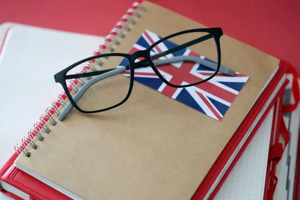 British language textbook and glasses are on table. Virtues of classic British language concept