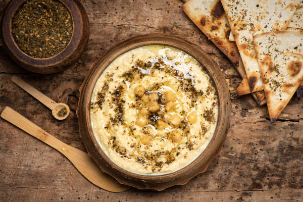 Homemade hummus dipping sauce with chickpeas and food ingredients Homemade hummus dipping sauce with chickpeas and food ingredients in a bowl on the table tabletop view hummus stock pictures, royalty-free photos & images