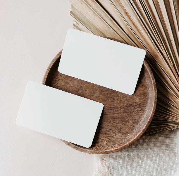 istock Card mockup with copy space top view, flat lay. Greetings, wedding invitations blank, paper sheet and dry palm leaf on beige background. 1327052904