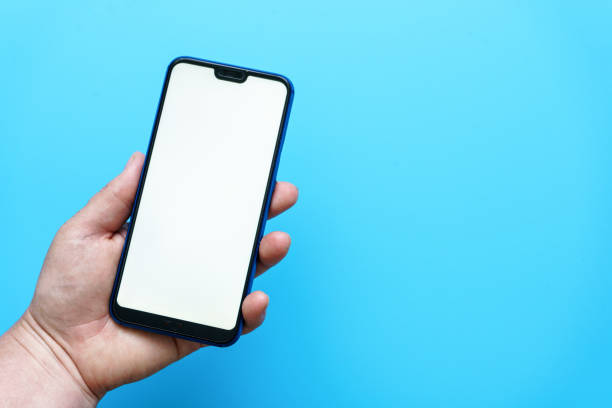 istock Female hand holding a smart phone against a blue background 1327054287