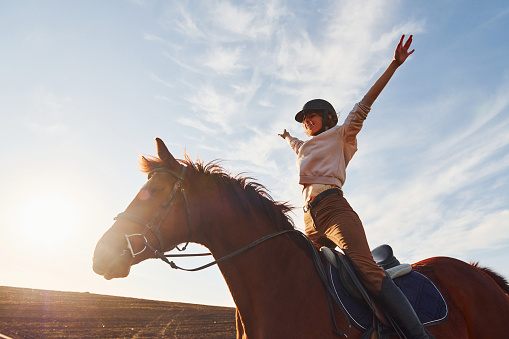 Mujer joven con sombrero protector con su caballo en el campo de la agricultura en el día soleado photo