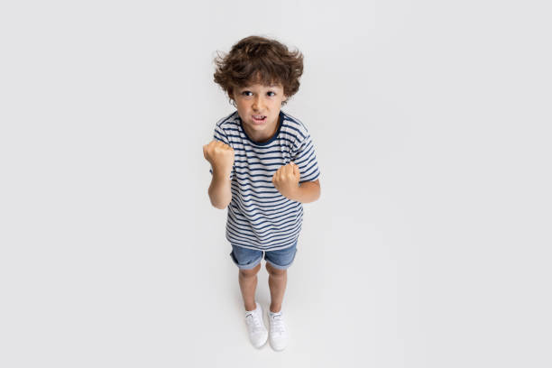 istock One little preschool boy posing isolated over white studio background. 1327054719