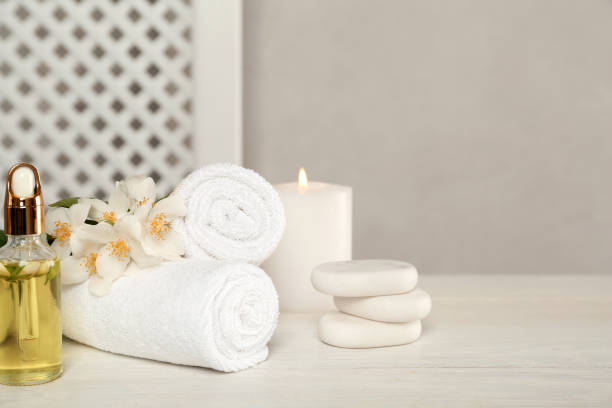 istock Composition with spa stones and beautiful jasmine flowers on white wooden table, space for text 1327055807