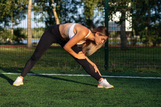 istock Slim athletic woman warms up before workout 1327058576