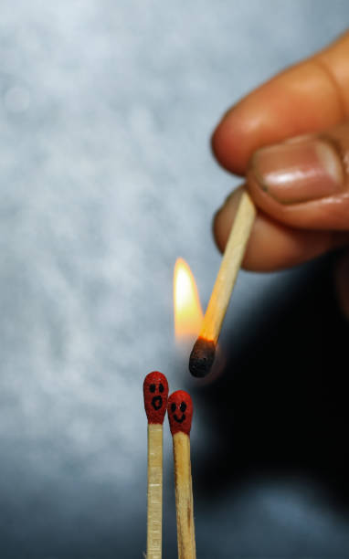 istock Two matches burning sitting together on the matchbox in the dark copy space. Two matches in flame as a metaphor of togetherness friendship, Love And Romance Concept. Matchstick art photography. 1327062375