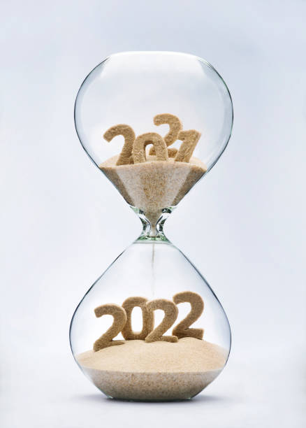 Passing into New Year 2022 New Year 2022 concept with hourglass falling sand taking the shape of a 2022 2021 stock pictures, royalty-free photos & images