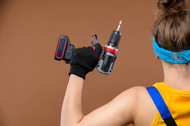 istock Back view energetic strong young Caucasian woman in a work uniform and goggles shows that she is strong with a screwdriver in her hand 1327063654