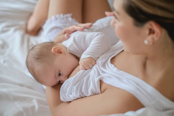 madre che allatta il suo bambino assonno - sucking asian ethnicity baby mother foto e immagini stock