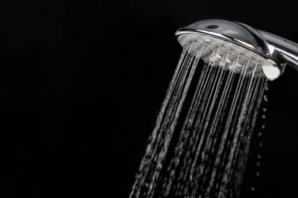 istock Scattering splashing water  by a shower head on a dark background 1327067601