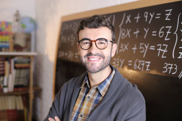 istock Math teacher holding pile of books 1327068249