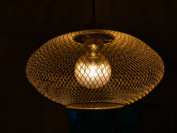 istock Side view of ceiling lamp with metal grid and illuminated bulb 1327068307