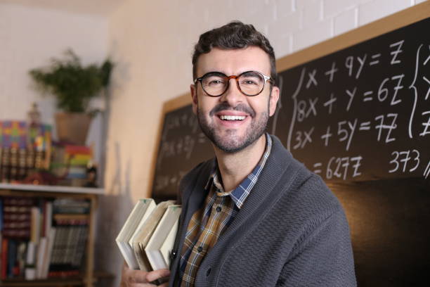 istock Math teacher holding pile of books 1327068773