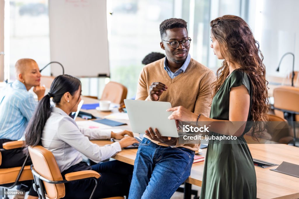 Multi ethnic group of businesspeople talking in the office Male graphic designer sharing ideas during meeting in modern office studio. Legal System Stock Photo