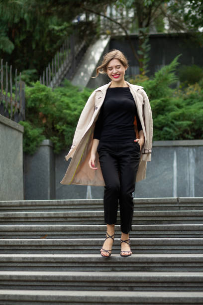 istock Delightful young woman going down the stairs 1327070772