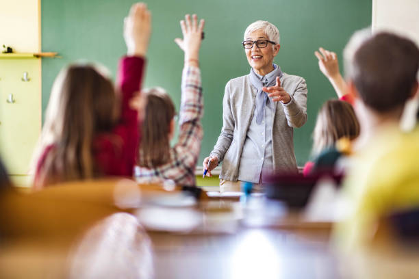 istock Happy senior teacher giving a lecture at elementary school. 1327071322
