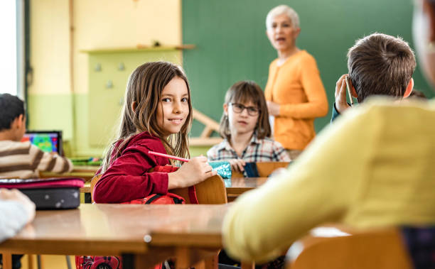 istock Happy schoolgirl on a class at elementary school. 1327072355