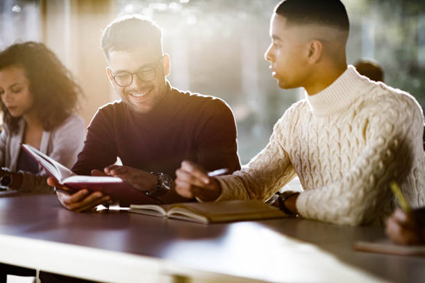istock Happy college students studying together on a class in classroom. 1327073318