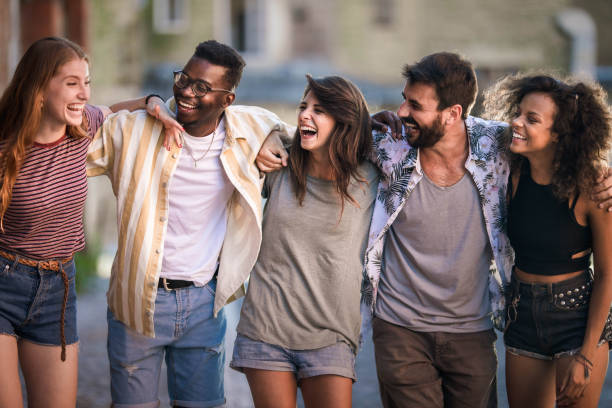 istock Cheerful friends talking while walking embraced on the street. 1327075037