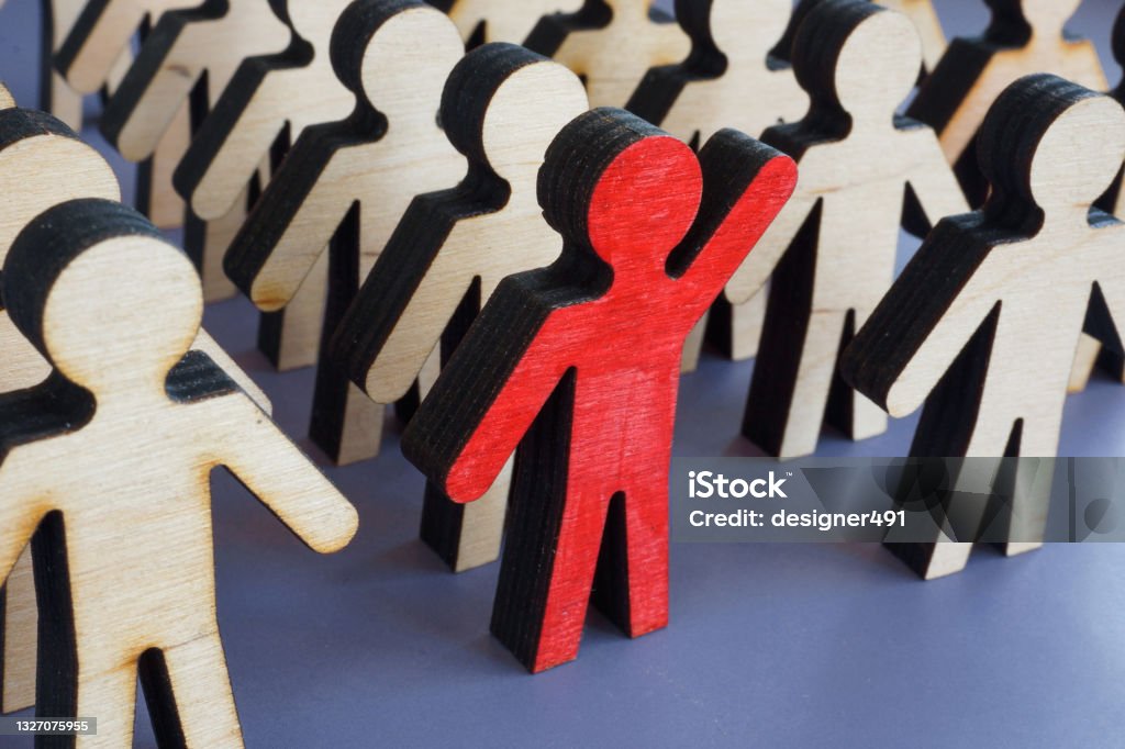 Initiative and activism concept. Unique figurine with a raised hand in a crowd. Individuality Stock Photo