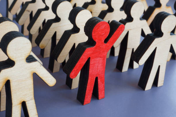 Initiative and activism concept. Unique figurine with a raised hand in a crowd. Initiative and activism concept. Unique figurine with a raised hand in a crowd. initiative photos stock pictures, royalty-free photos & images