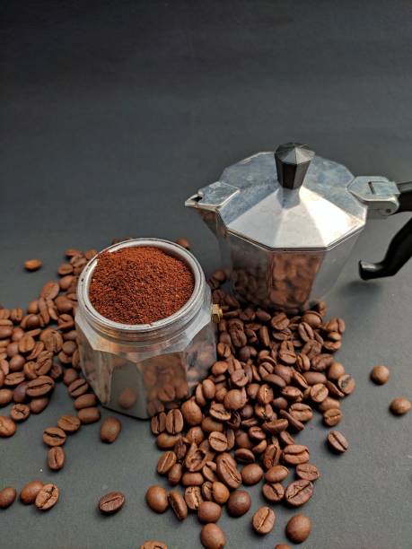 istock Moka coffee pot with coffee beans on moka base isolated on black background 1327076210