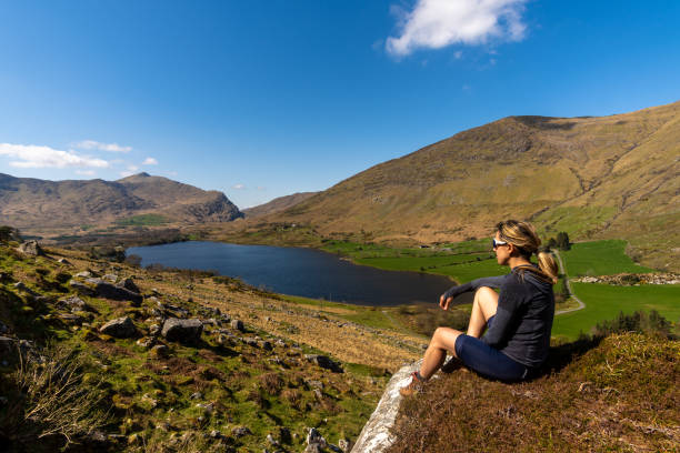 istock Sitting cyclist woman looking at mountaimous landscape 1327078544