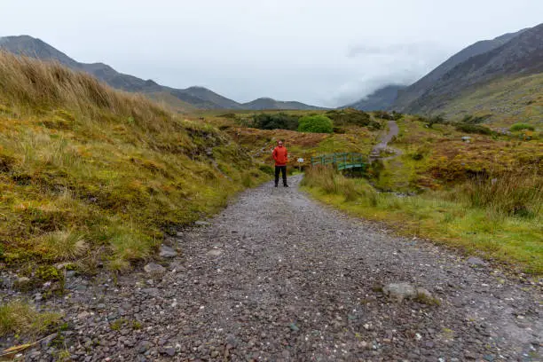 Man walking on mountain path in Kerry Mountains Ireland