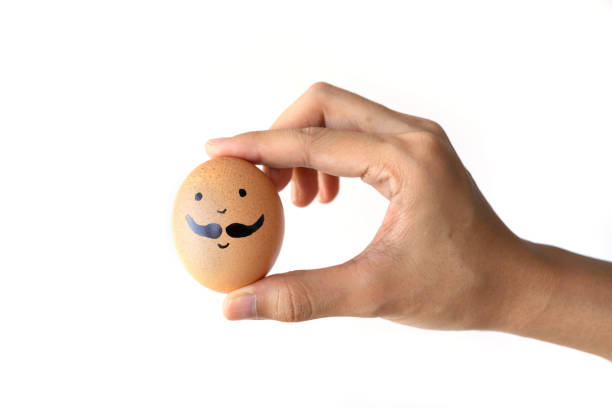 istock A hand holding an emotional brown egg face. Creative face character shell painted isolated on white background. 1327079214