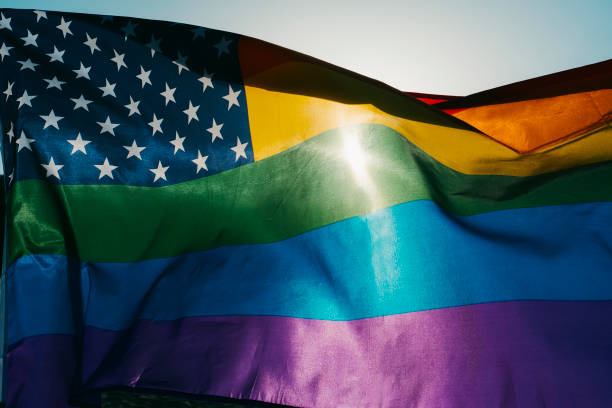 istock a rainbow US flag is waving on the sky 1327079276