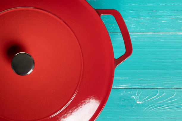 istock Red enameled pan with two handles on turquoise table 1327082039