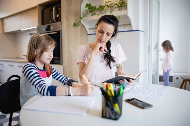 istock Daughter doing her homework and mother overseeing how she works 1327082898