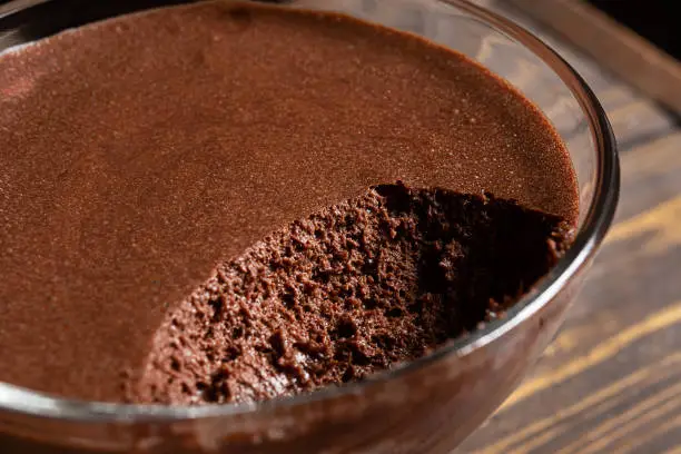 A transparent bowl with chocolate mousse - traditional French dessert close-up