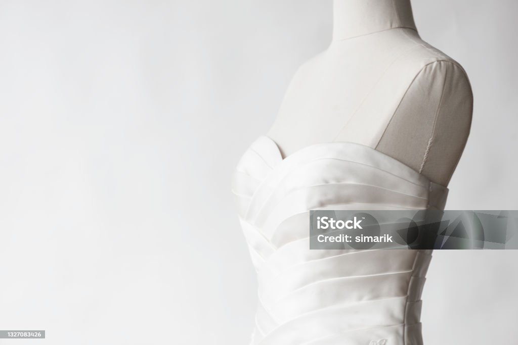 Wedding Dress Wedding dress on tailor mannequin in front of white wall. Wedding Dress Stock Photo