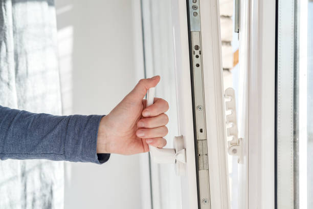 istock Hand opens a PVC window, holding the handle in an upright position, with a fixing device attached to the frame for ventilation. 1327083592