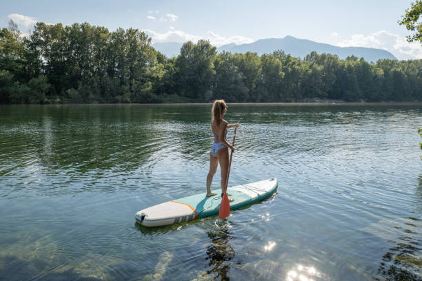 istock Woman paddling on a stand up paddle board 1327086474