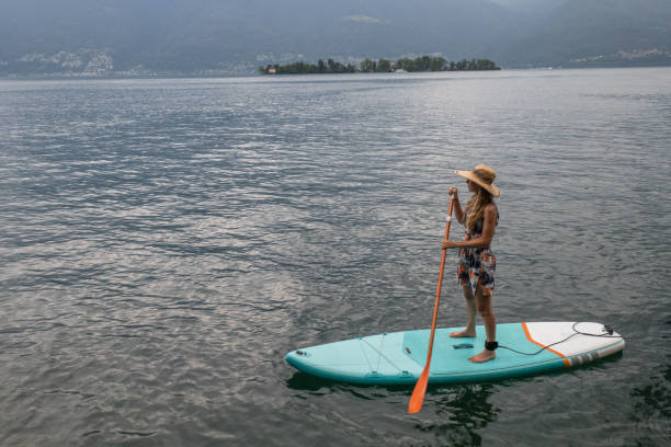 stand up paddle with a view, woman on sup in the mountains - switzerland forest storm summer imagens e fotografias de stock