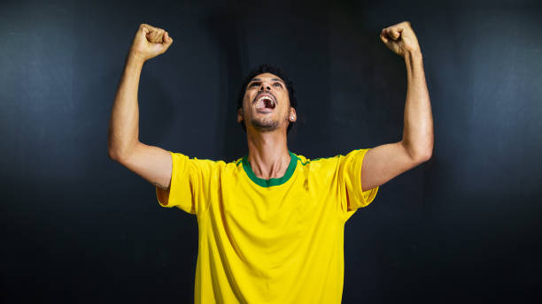 istock Olympics happy black man fan in uniform isolated on black background. Space for text. 1327088093