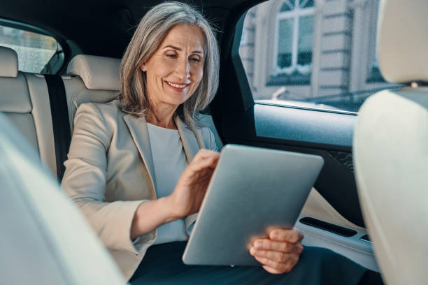 istock Mature beautiful woman in smart casual wear using digital tablet 1327089298
