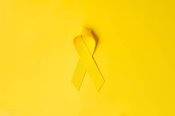 Yellow Ribbon on yellow background for supporting people living and illness. September Suicide prevention day, Childhood Cancer Awareness month and World cancer day concept Yellow Ribbon on yellow background for supporting people living and illness. September Suicide prevention day, Childhood Cancer Awareness month and World cancer day concept september stock pictures, royalty-free photos & images