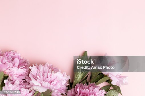 istock Frame wreath of pink peony flowers with copy space for text on pastel marble background. Flat lay, top view. 1327090238