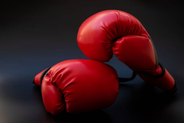 istock Pair of red leather boxing gloves on black background 1327091037