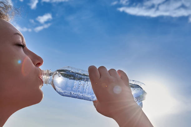 istock A woman drinks clean transparent water from a plastic bottle. 1327091768