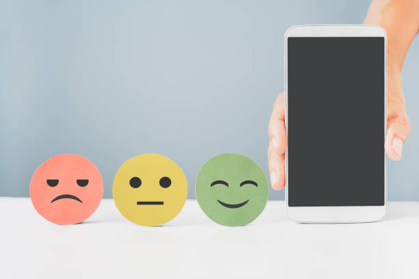istock hand holding mobile phone with clipping path and emotion face for customer review, comment, experience, satisfaction survey, feed back concept 1327092634