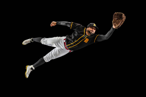 istock Flying. Baseball player, catcher in sports uniform and equipment practicing isolated on a black studio background. Team sport concept 1327093343