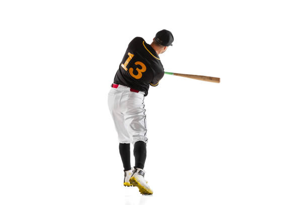 istock Baseball player, pitcher in a black white sports uniform practicing isolated on a white studio background. Back view 1327093360